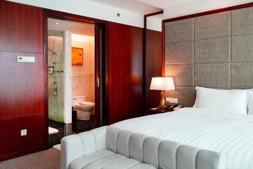 上海上海斯格威铂尔曼大酒店的一间带大床的卧室和一间浴室