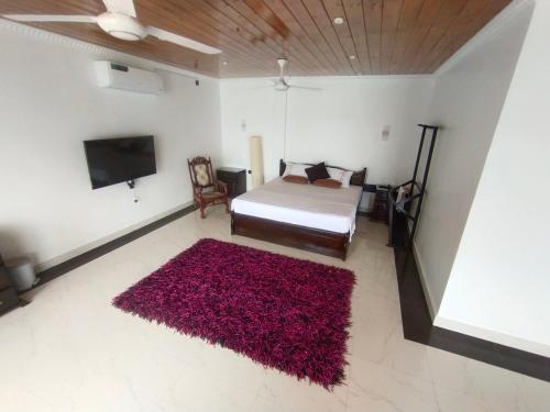 亭可马里Sellamah beach Hotel的一间卧室配有一张床和红色地毯