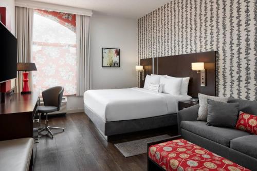 华盛顿华盛顿市中心费尔菲尔德万豪套房酒店的酒店客房配有一张床、一张书桌和一张沙发。