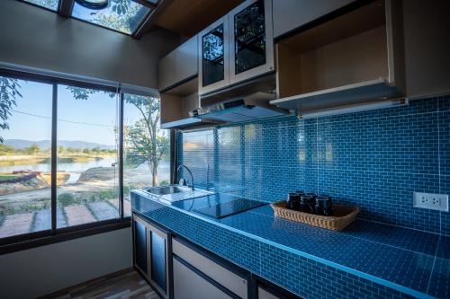 清迈Mana-An Lake Hill Resort Villa的一个带水槽和大窗户的厨房