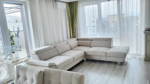 锡比乌SIBIU Bach Penthouse的客厅配有白色沙发和大窗户