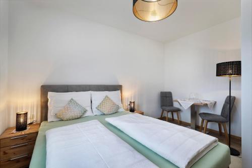 思科纳Lothof的一间卧室配有一张带两把椅子和一张桌子的床。