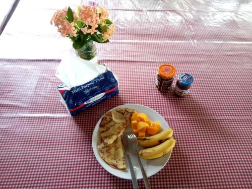 美娜多Lorenso Cottage的桌上一盘带香蕉和水果的食物