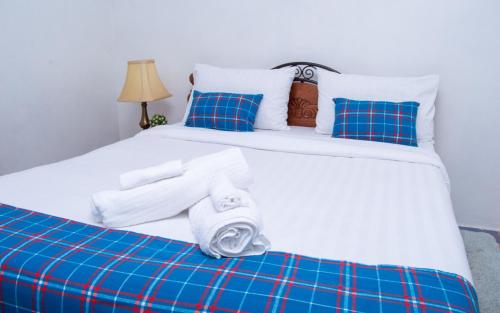 内罗毕Elegant Touch Home - 2 Bedroom House in Karen的一张带蓝色枕头的白色床和毛巾