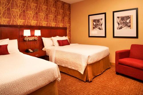 赫兰德霍兰托莱多机场万怡酒店的酒店客房,设有两张床和一张红色椅子