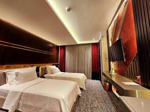 MidyatAsur Imperıal Hotel的酒店客房设有两张床和电视。