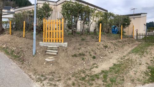 维莱福尔Petite maison VILLEFORT的泥土上有一个黄色门的游乐场