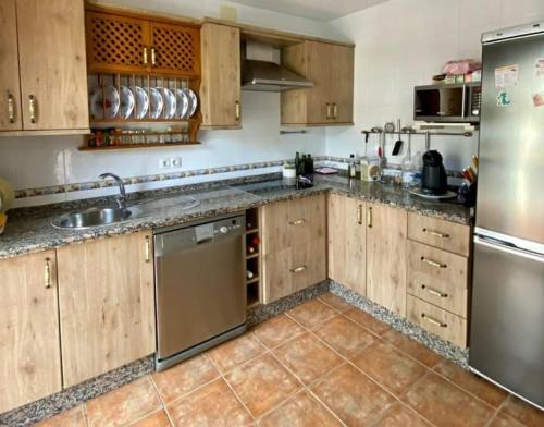 埃尔博斯克CASA RURAL EN URB LAs TRUCHAS-EL BOSQUE的厨房配有木制橱柜和不锈钢用具