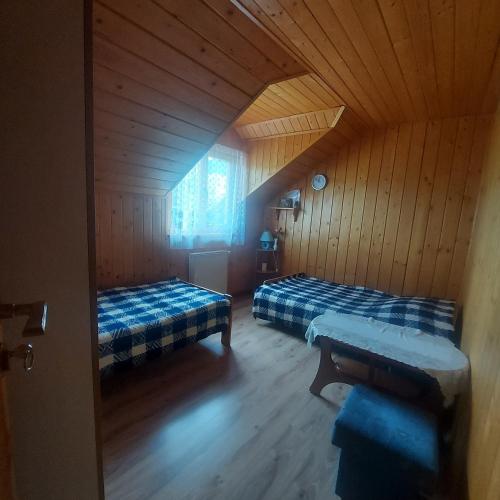 SablówkaPokoje Gościnne u Huberta的小木屋内带两张床的房间