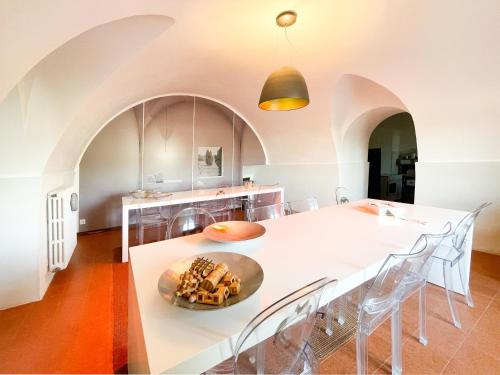 恩纳La Casa del Poeta Enna - Pergusa的厨房配有白色的大桌子和椅子