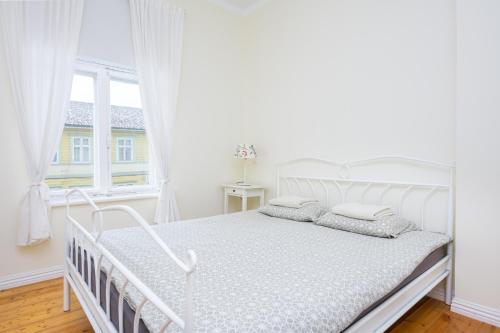 派尔努Ringi Apartments的白色卧室内的一张白色床,设有窗户