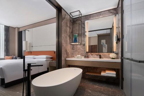 天津国家会展中心天津万豪酒店的带浴缸、床和镜子的浴室