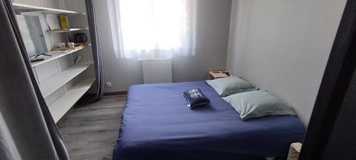 普勒尔蒂Chambre chez Sylvain的一间小卧室,配有一张蓝色的床和窗户