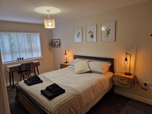 伯明翰Stylish 2 Bedroom Apartment Sleeps 4 Contractors and Corporates Welcome的一间卧室配有一张床、一张书桌和一个窗户。