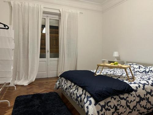 里斯本SÓLO HABITACIÓN GRANDE CON BALCOn的一间卧室配有一张床、一张桌子和一个窗户。
