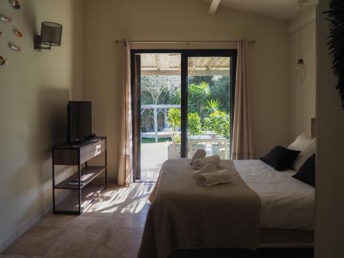 博尼法乔Songes d’été的一间卧室设有一张床和一个滑动玻璃门
