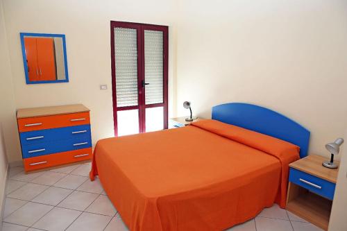 普拉亚·阿马勒Residence Soleluna的一间卧室配有橙色的床和蓝色椅子