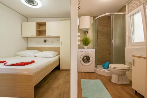迪斯诺Beachhouse Smiley Two的一间卧室配有一张床和一台洗衣机