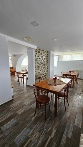 科尔贝尼Pensiunea Tesoro的用餐室配有木桌和椅子