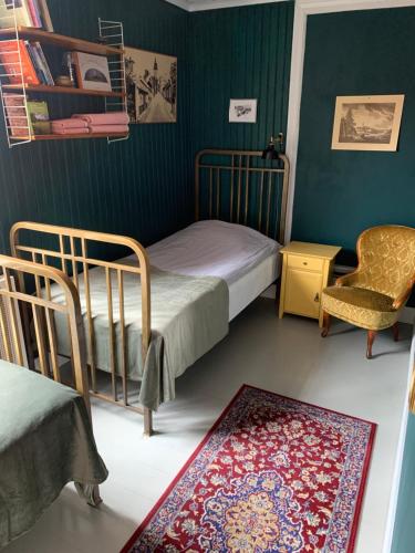 斯特兰奈斯Pensionat Gyllenhjelmsgatan的卧室配有两张床、椅子和地毯。