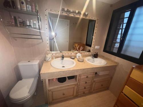 阿尔沃洛特Casa con picina en Granada.的浴室设有2个水槽、卫生间和镜子。