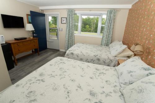 Shaftsbury州长岩石汽车旅馆的一间卧室配有两张床和电视。