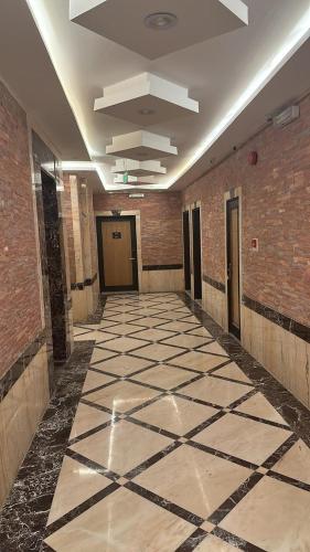 麦地那ريف الشرق للشقق الفندقية的大楼内铺有瓷砖地板的走廊