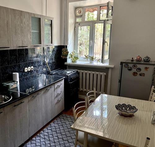 塔什干Humo Family Home的厨房配有桌子、水槽和炉灶。