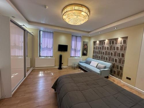 赖盖特Lovely apartment near Gatwick airport的一间卧室配有一张床、一张沙发和一个吊灯。