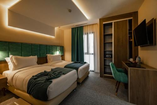 HydraAD Hotel Pont D'Hydra的酒店客房设有两张床和电视。