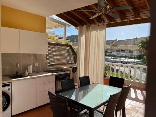 美洲海滩El Camison Apartment的一个带桌椅的厨房和一个阳台
