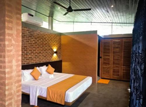 乌纳瓦图纳Avera Hills Villas Unawatuna的一间卧室设有一张床和砖墙