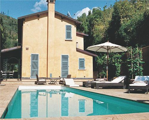 彼得拉桑塔Spazio d'arte relais的一座带房子的建筑前的游泳池