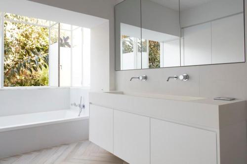 荷兹利亚Luxury SeaSide DeShalit Square的白色的浴室设有两个盥洗盆和镜子