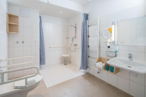 万根沃格Strandhotel Gerken的白色的浴室设有水槽和淋浴。