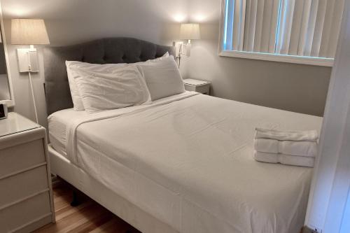 棕榈岛Sea Cabin 306-A的卧室配有白色的床单和枕头