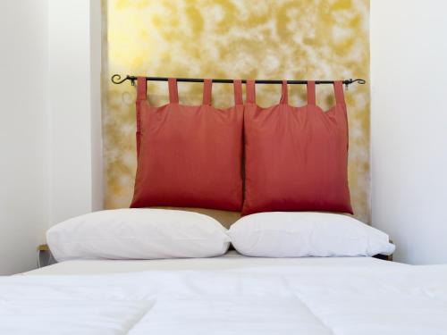 格拉维纳普利亚Gravina suite Apartment的床上有两个红色枕头的床
