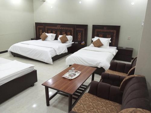 伊斯兰堡Hotel AL MARKAZ的酒店客房,设有两张床和一张茶几