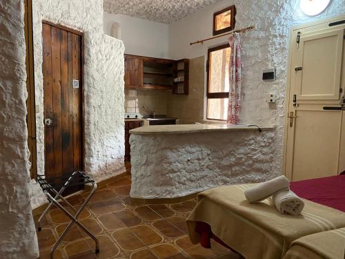兰佩杜萨Villaggio La Roccia camping的厨房设有石墙和桌子
