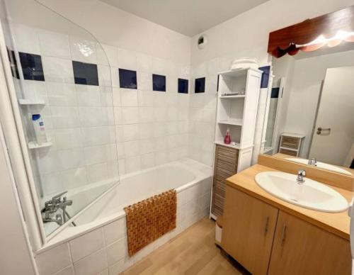 于斯图GUZET-Pyrénées-Pied des pistes的浴室配有白色浴缸和水槽