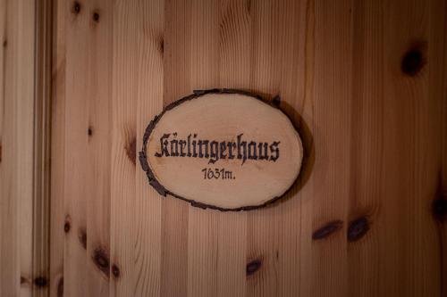 柯尼希斯湖畔舍瑙Haus BergGesundZeit Doppelzimmer Kärlingerhaus的木墙,上面有标志