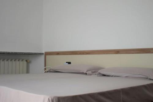 克雷莫纳Appartamento Dante的一张白色的床,在房间内配有木制床头板