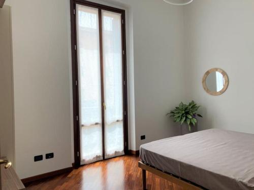 克雷莫纳Appartamento Dante的一间卧室设有一张床和一个大型滑动玻璃门