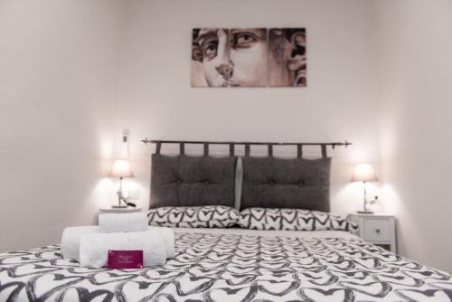 佛罗伦萨Luxury Home Il Giglio的一间卧室配有一张带两盏灯的黑白床。