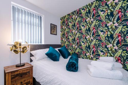 埃杰顿4 bed property, Bolton , Manchester的一间卧室配有一张带蓝色枕头的床。