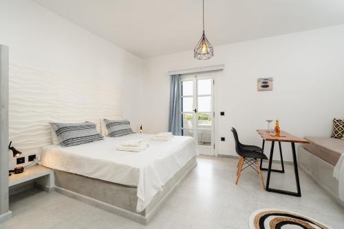 米科利维亚Diamantis Studios&Apartments的白色卧室配有床、书桌和椅子