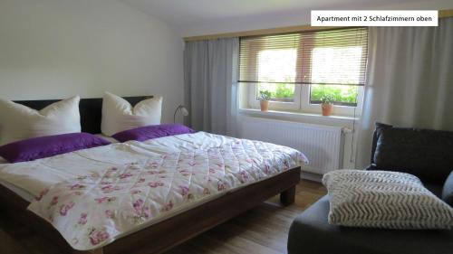 韦尼格罗德Ferienwohnung Wolfsholz的一间卧室配有一张带紫色枕头的床和窗户。