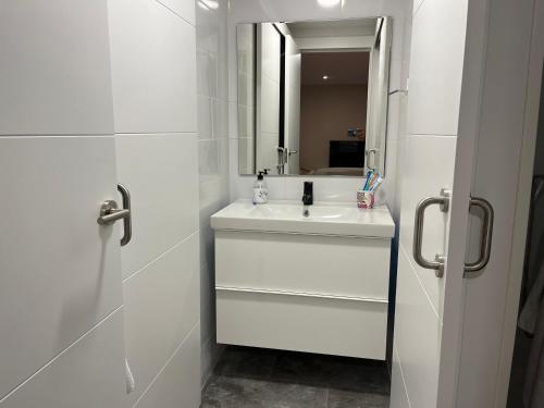 卢安科apartamento luanco playa的白色的浴室设有水槽和镜子