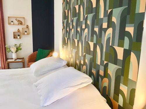 塞夫里耶VUE LAC LODGES的卧室配有一张带两个枕头的床和色彩缤纷的墙壁