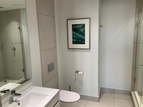 米德兰5 Star Elegant Apartments, Ellipse Waterfall City, Midrand, Johannesburg的白色的浴室设有水槽和卫生间。